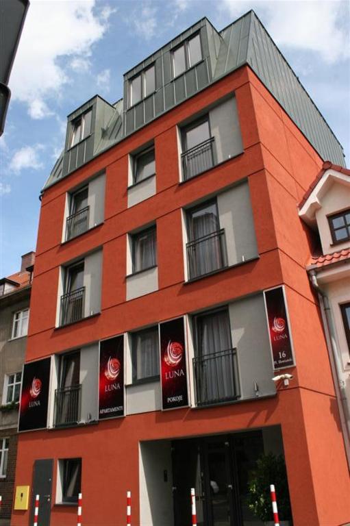 a red building with signs on the side of it at Luna in Zielona Góra