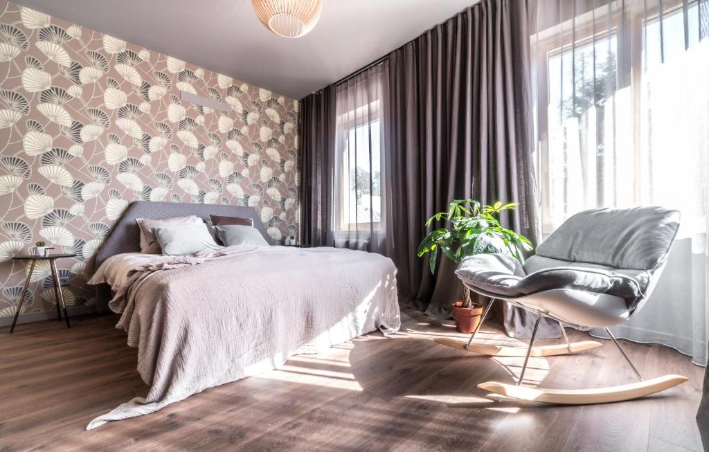 Tamara Suites & Apartments في يورمالا: غرفة نوم بسرير وكرسي