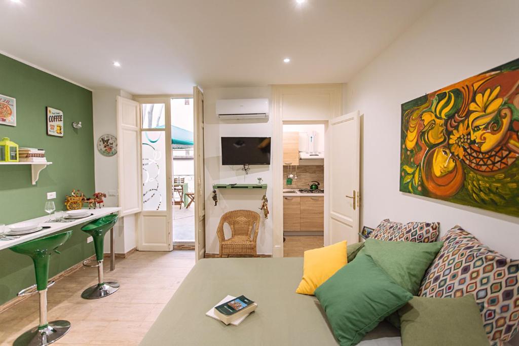 Una sala de estar con un sofá y una cocina. en Il Tempo Ritrovato - Locazione ad uso turistico, en Palermo