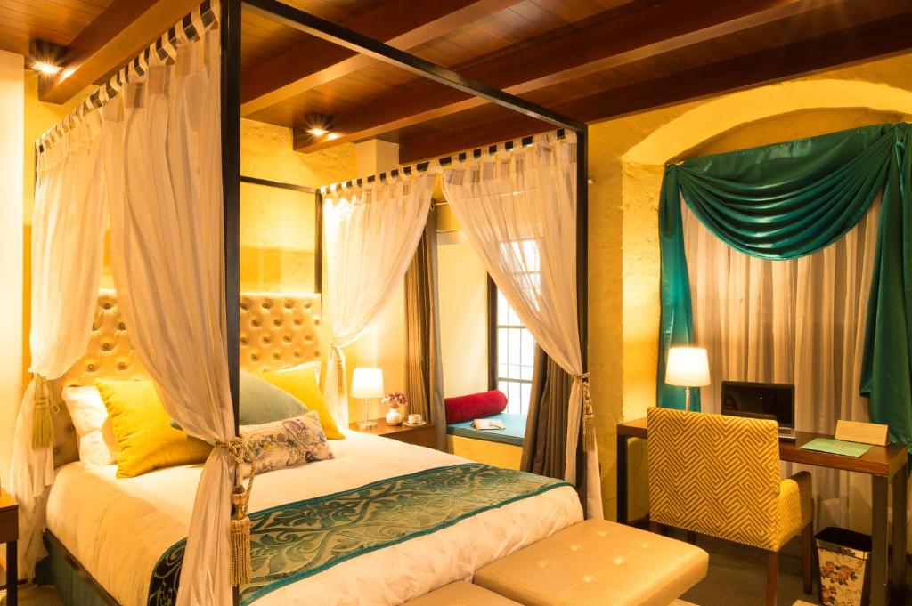 1 dormitorio con cama con dosel y escritorio en Costana 702 Hotel Boutique, en Arequipa