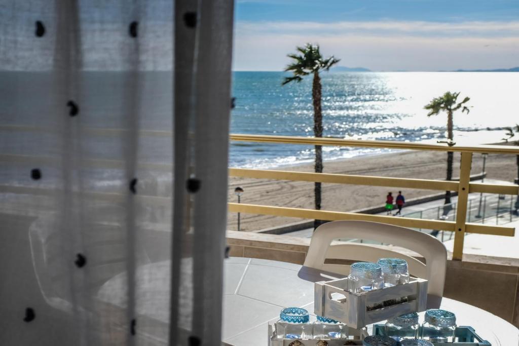 a table with water glasses on a balcony with the beach at Apartamentos Marina sol de España in Cambrils