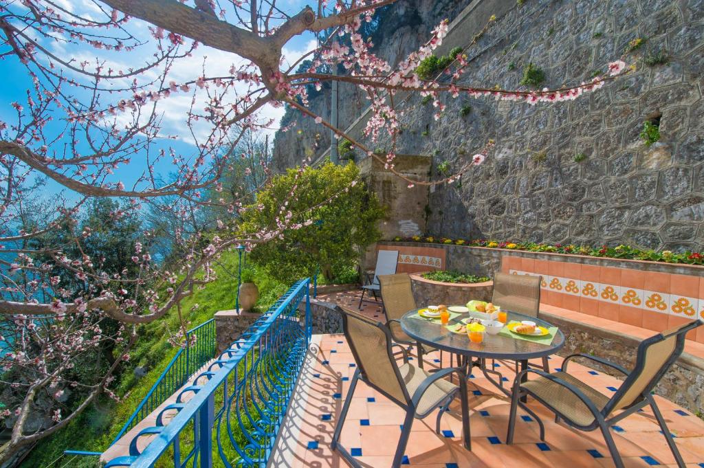 stół i krzesła na balkonie ze ścianą w obiekcie Casa Pina w Amalfi