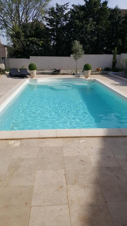 uma grande piscina azul num quintal em le Cabanon de LEA em Tavel