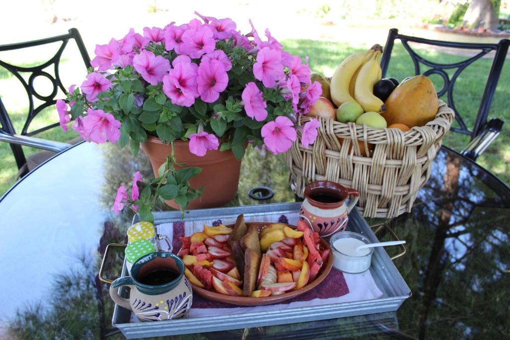 a tray of fruit and vegetables on a table with flowers at Rancho El Campanario en La Ruta del Vino in Valle de Guadalupe