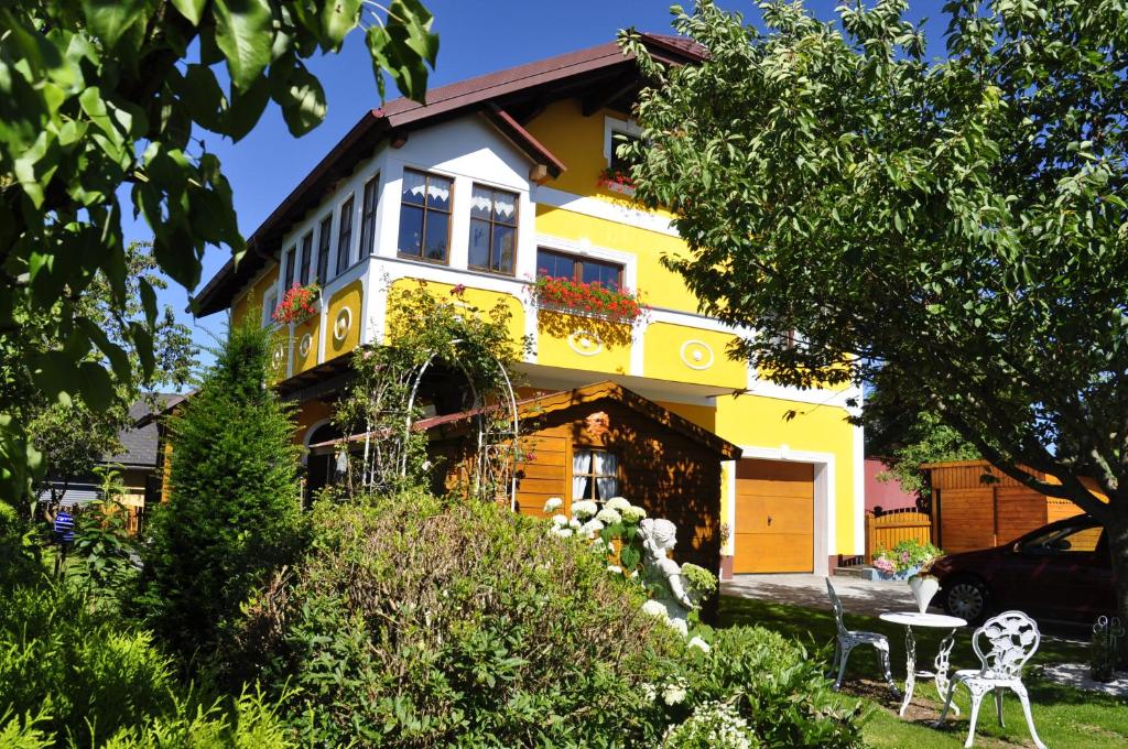 uma casa amarela com uma mesa em frente em Ferienwohnung Hinterdorfer em Unterweissenbach