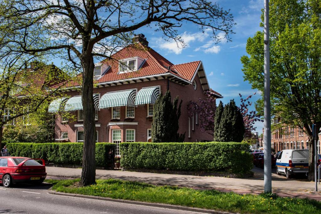 een stenen huis met een rood dak op een straat bij B&B De Schiedamse Suites in Schiedam
