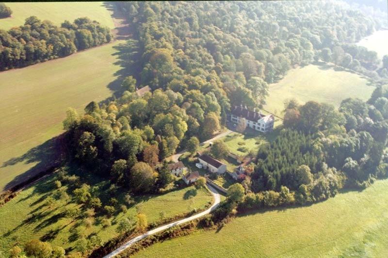 eine Luftansicht eines Hauses auf einem Feld mit Bäumen in der Unterkunft Gîte et Chambres d'hôtes du Domaine du Val Bruant in Arc-en-Barrois