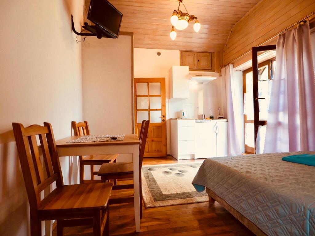 a bedroom with a dining room table and a kitchen at Willa Dutka - Apartamenty in Szczawnica