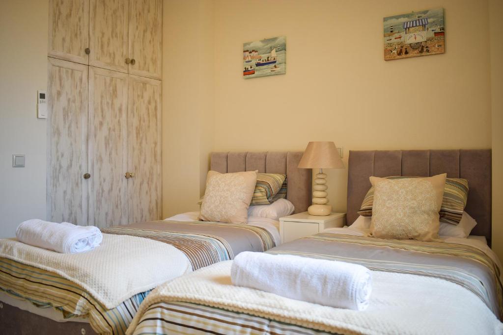 1 dormitorio con 2 camas y toallas. en Blue View House en Corfú