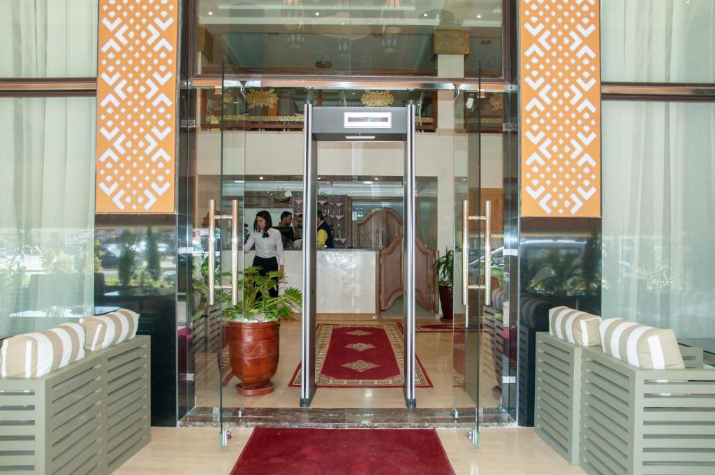 Sidi Bennour的住宿－Sania Hotel，大堂设有玻璃门,里面装有植物