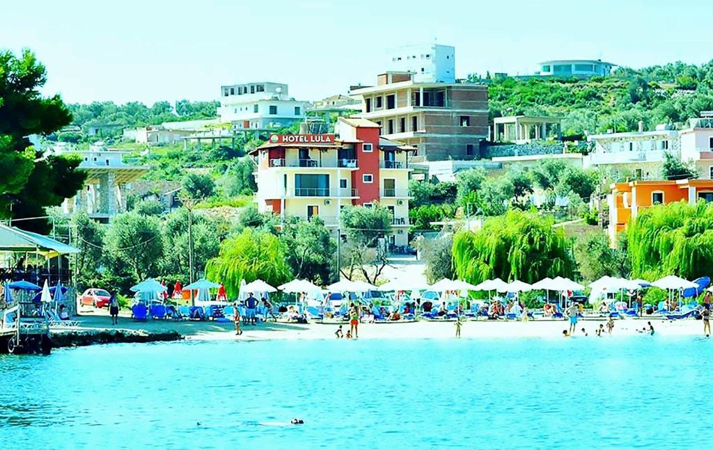 un gruppo di persone su una spiaggia con edifici di Hotel Lula Ksamil a Ksamil