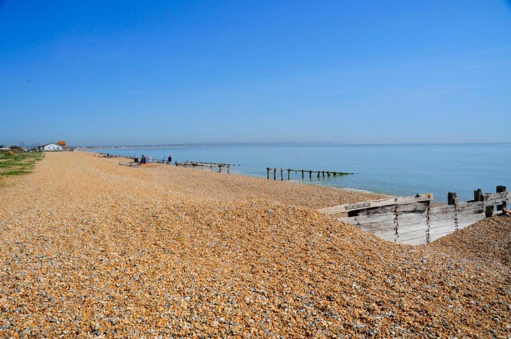 a rocky beach with a pier and the ocean at LUXURY BEACHFRONT OUTSTANDING 2 bedroom APARTMENT in Eastbourne