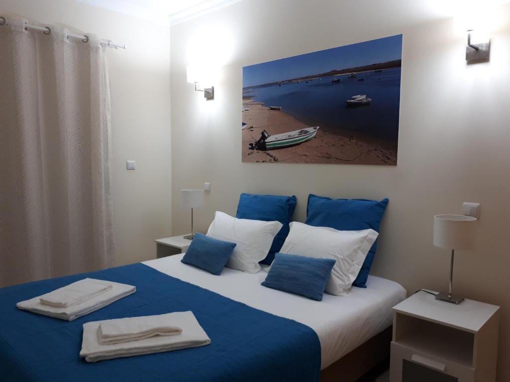 カバナス・デ・タビラにあるCabanas Family Apartmentのベッドルーム1室(青と白の枕が備わるベッド1台付)
