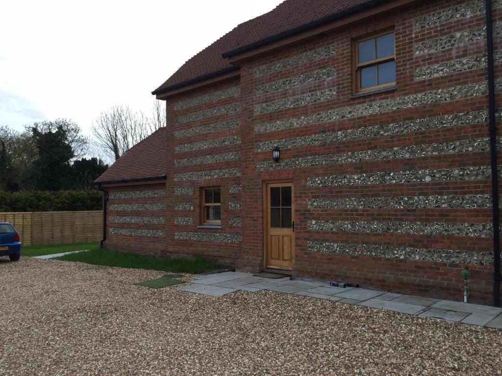 una casa in mattoni con una porta e una macchina parcheggiata di fronte di The Old Dairy B and B a Salisbury