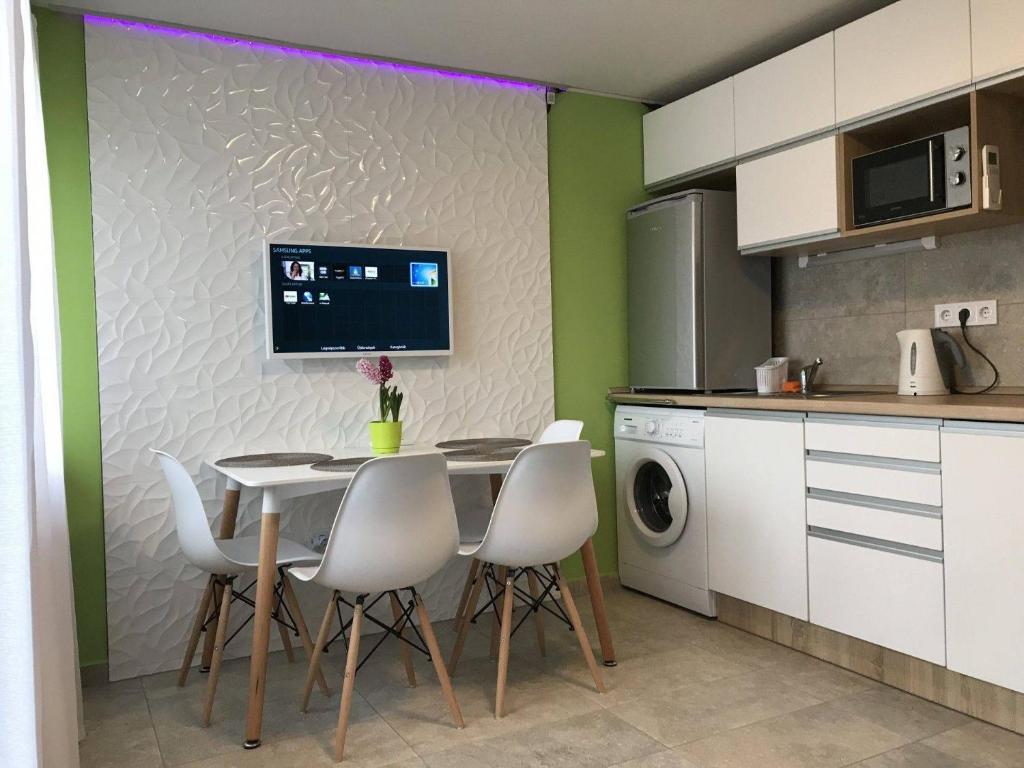 ザマールディにあるRKCZ40 - Design apartment at the Heart of Balatonのキッチン(テーブル、椅子、電子レンジ付)