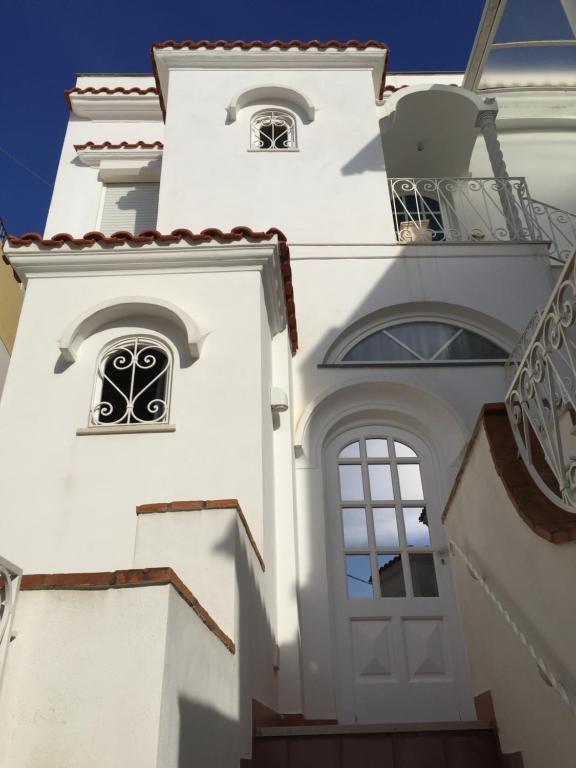 a white building with two windows and a balcony at To Be Capri in Capri