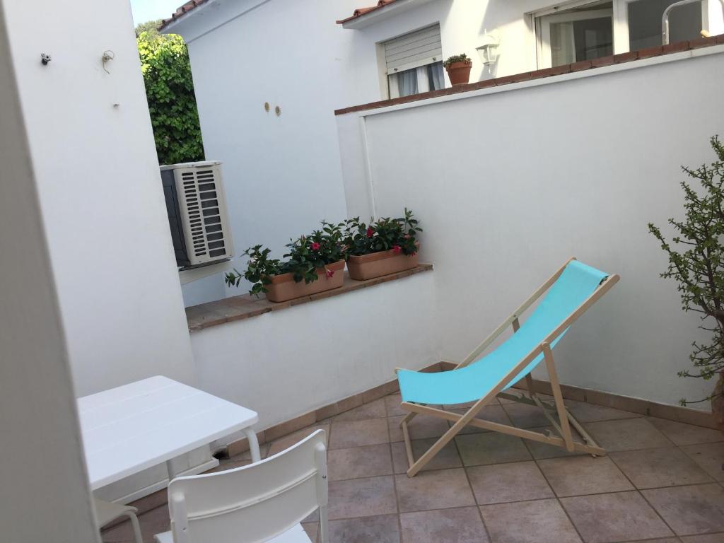 a blue chair and a table on a balcony at To Be Capri in Capri