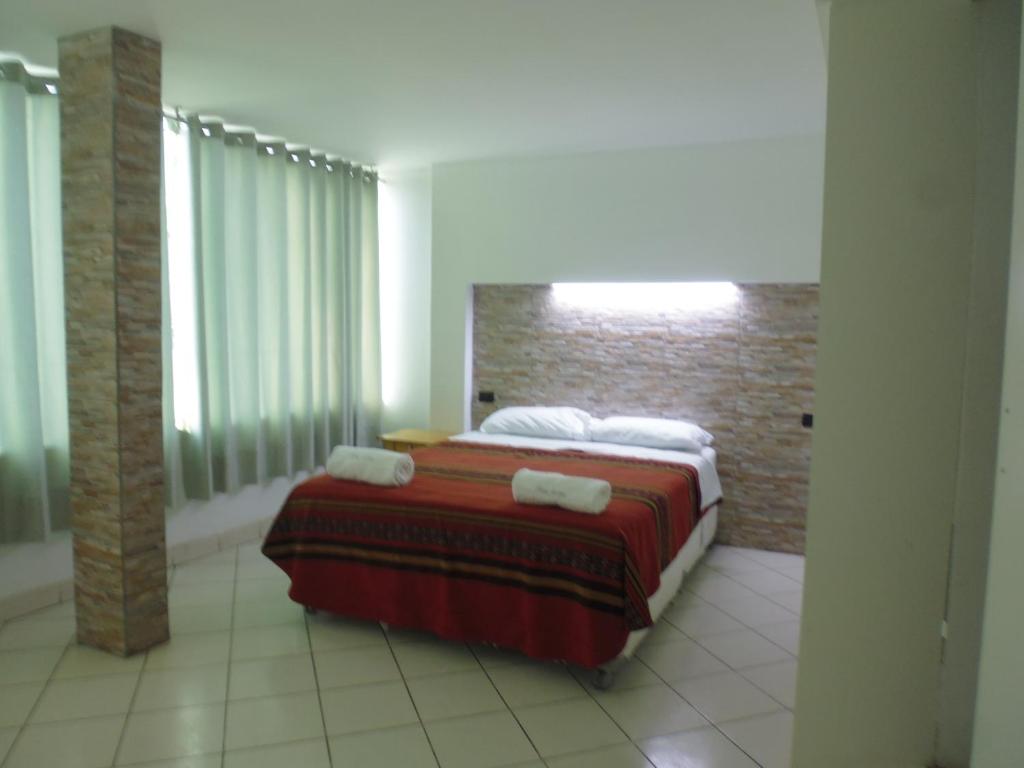1 dormitorio con 1 cama con toallas en Hostal Fatima, en Huacho