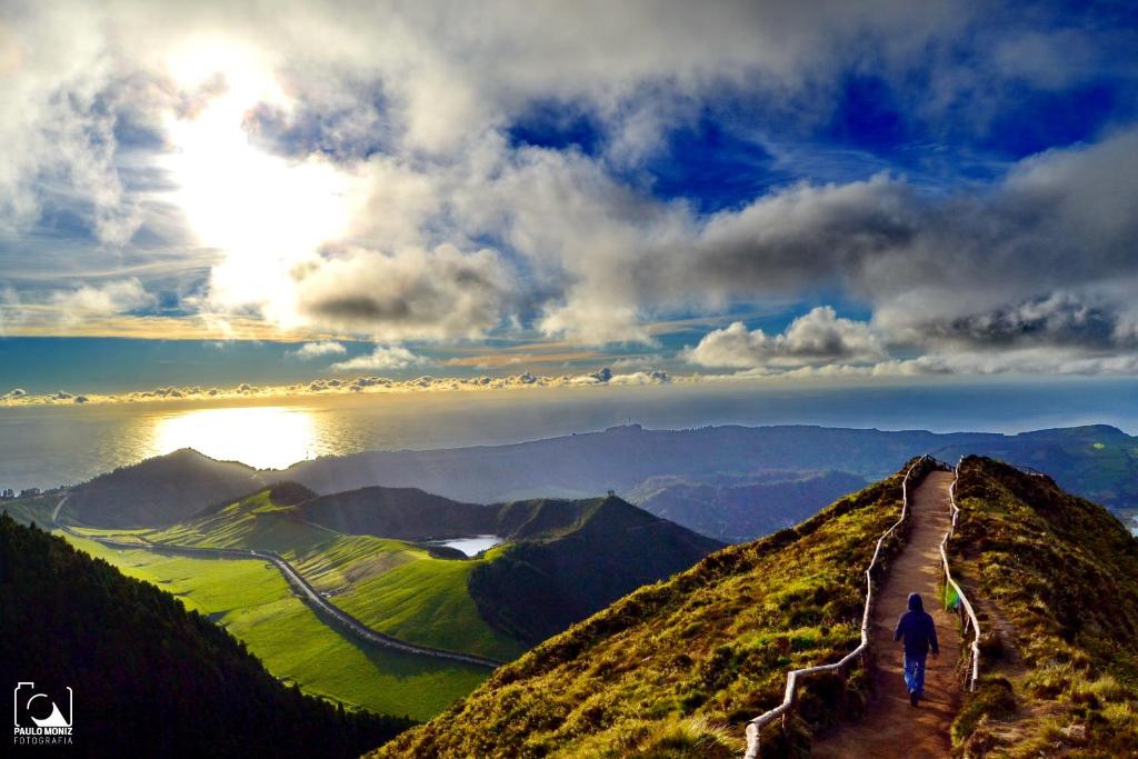 un hombre caminando por un camino en una montaña en LAGOON'S HOUSE, en Sete Cidades