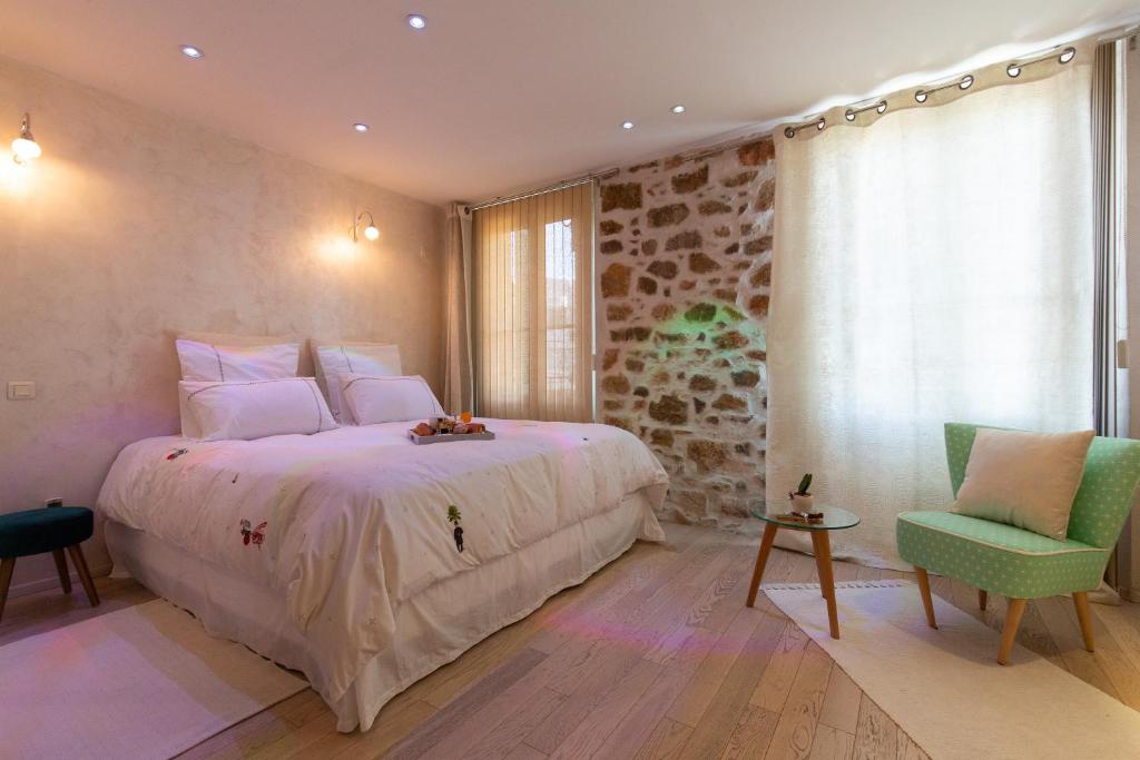 1 dormitorio con 1 cama grande y 1 silla en Aby, en Cannes