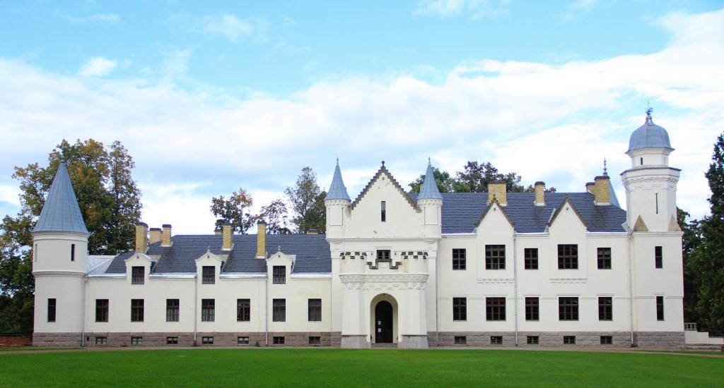 a large white castle with a tower at Alatskivi Castle in Alatskivi