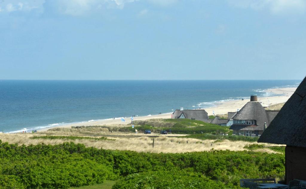 uma vista para uma praia com casas e o oceano em Ferienwohnung Kliffsand em Kampen