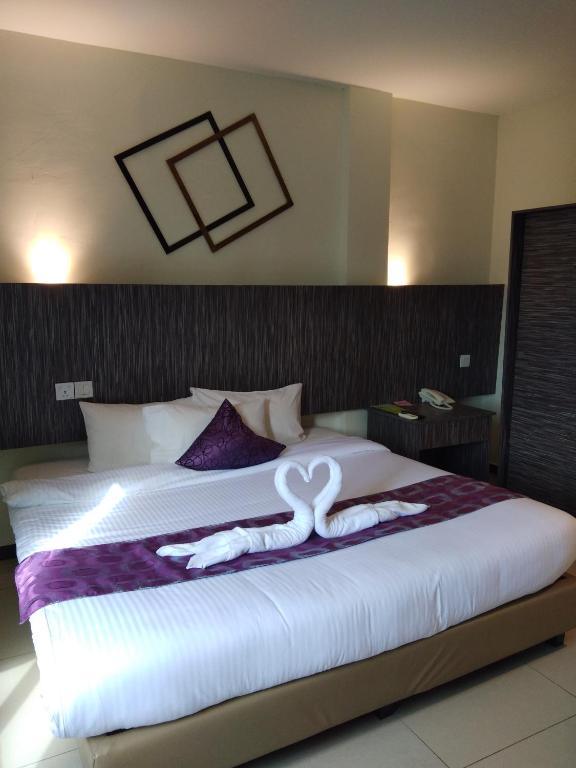 a bedroom with a bed with two swans on it at Salsa Resort Langkawi By Casa Loma in Pantai Cenang