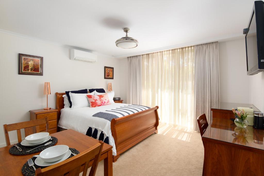 a bedroom with a bed and a table and a dining room at Luna Blu - Luxury B&B in Rhyll