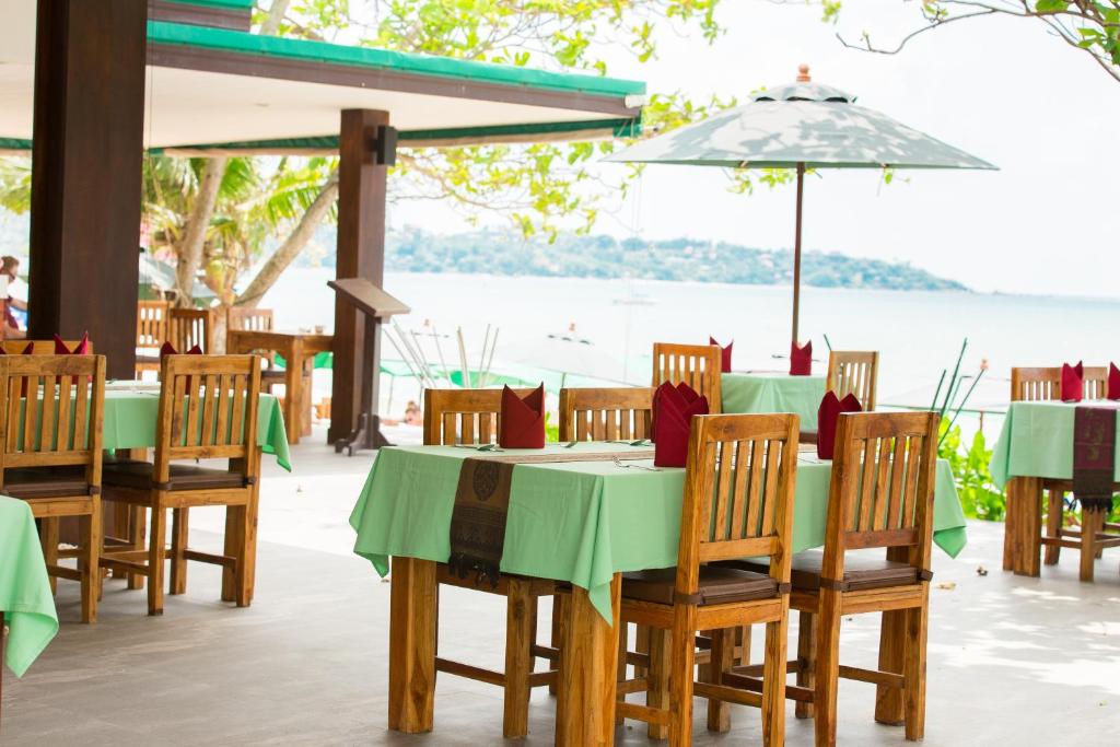a restaurant with tables and chairs with a view of the water at Lamai Coconut Beach Resort in Lamai