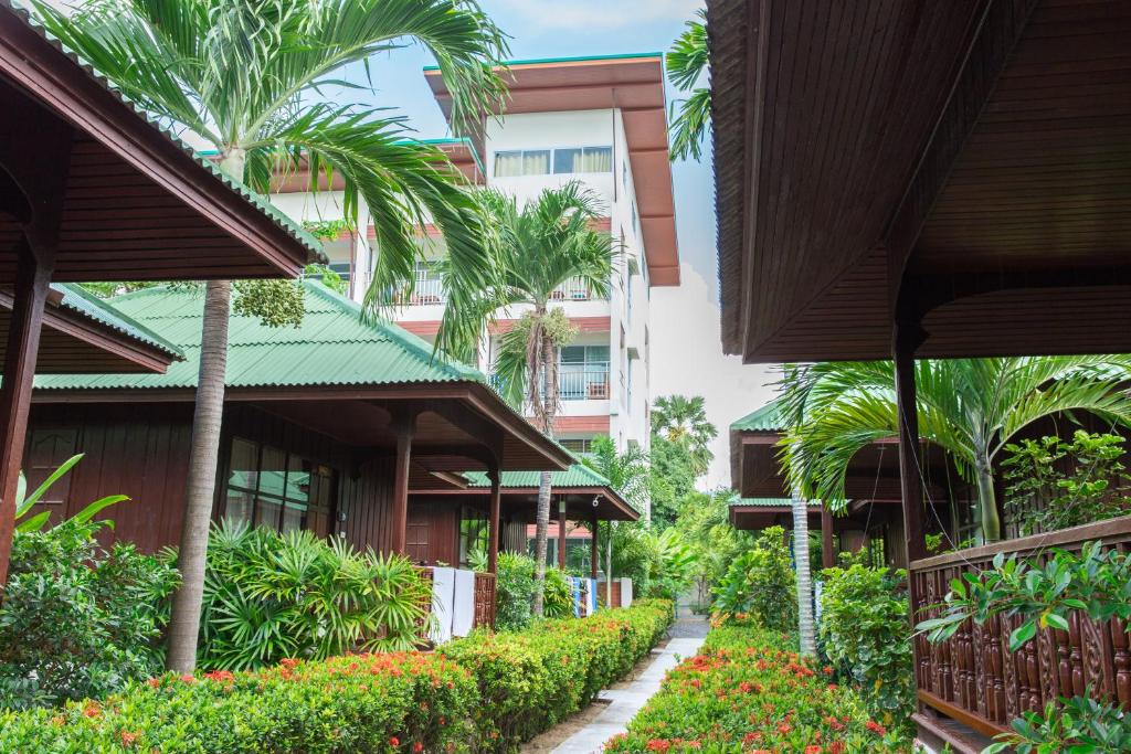 a walkway through a building with palm trees and flowers at Lamai Coconut Beach Resort in Lamai