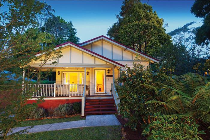 a small house with a porch and stairs to it at Brantwood Cottage Luxury Accommodation in Blackheath