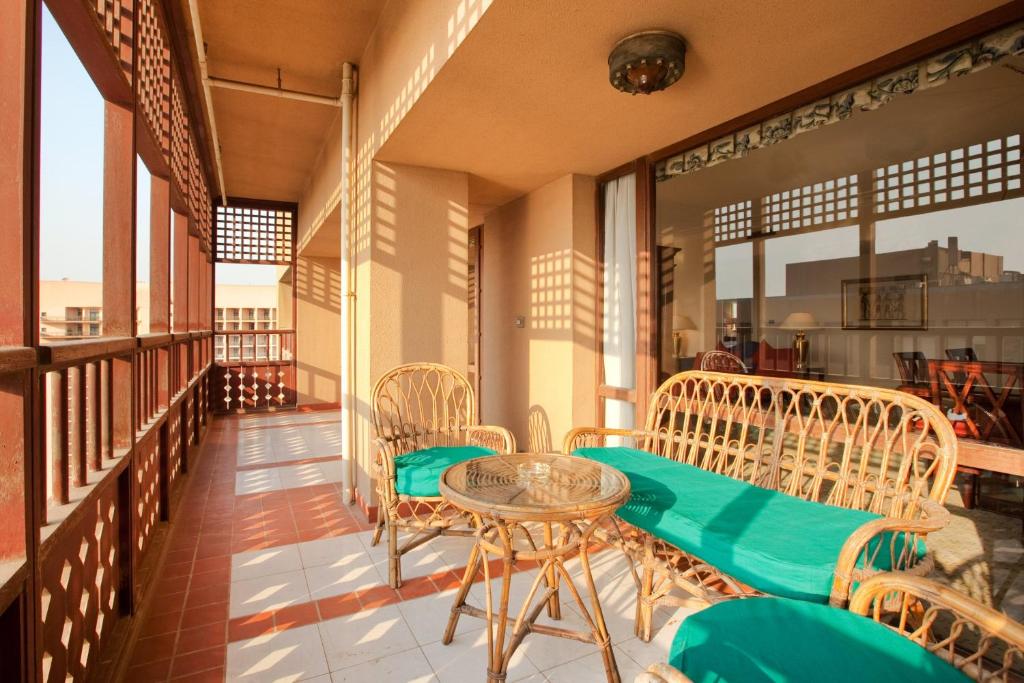 a balcony with chairs and a table and some windows at Cairo World Trade Center Hotel & Residences in Cairo