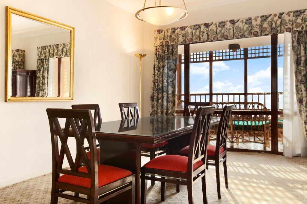 a dining room with a table and chairs and a mirror at Cairo World Trade Center Hotel & Residences in Cairo