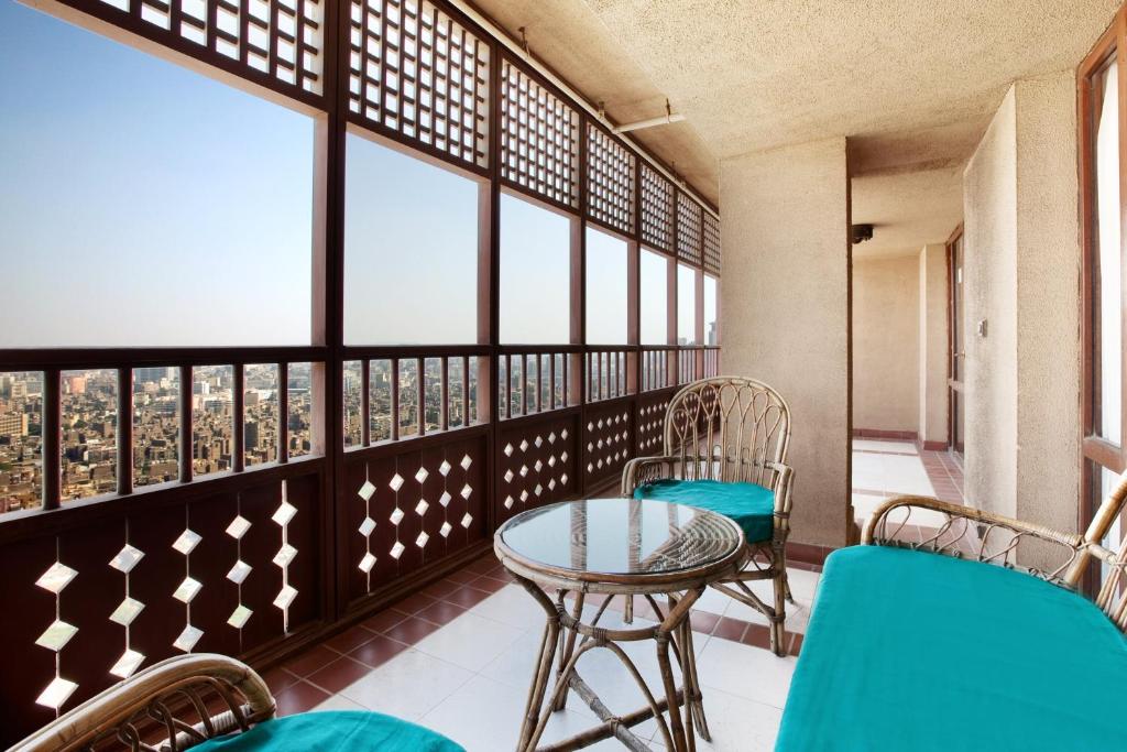 a balcony with a table and chairs and windows at Cairo World Trade Center Hotel & Residences in Cairo