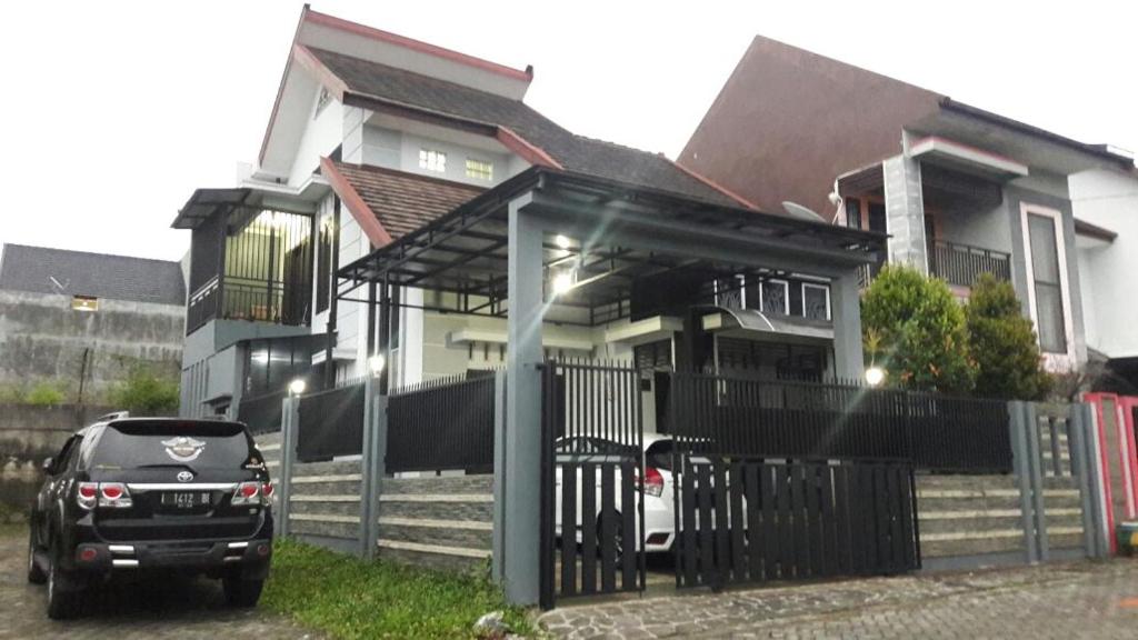 ein vor einem Haus geparkt in der Unterkunft Villa Pesanggrahan Kusuma Batu in Batu