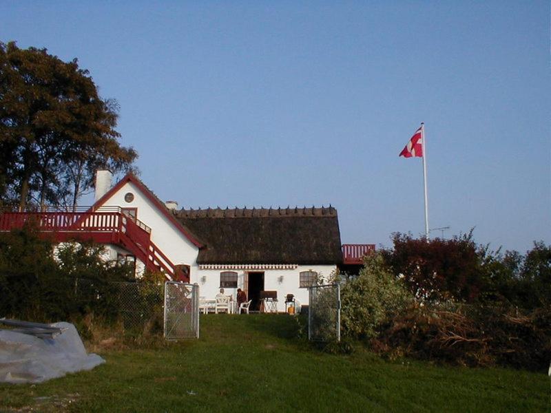 una casa blanca con una bandera canadiense delante de ella en Bulbrovejs Bed & Breakfast, en Havdrup