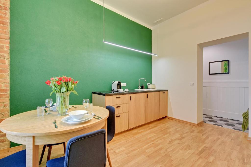 ソポトにあるLion Apartments - Unique 755の緑の壁のダイニングルーム(テーブル付)