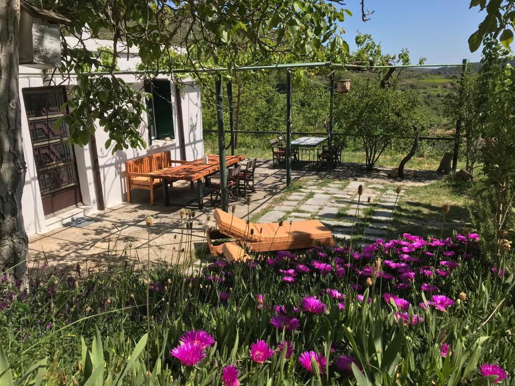 een patio met een tafel en bloemen in de tuin bij Temenia House in Teménia