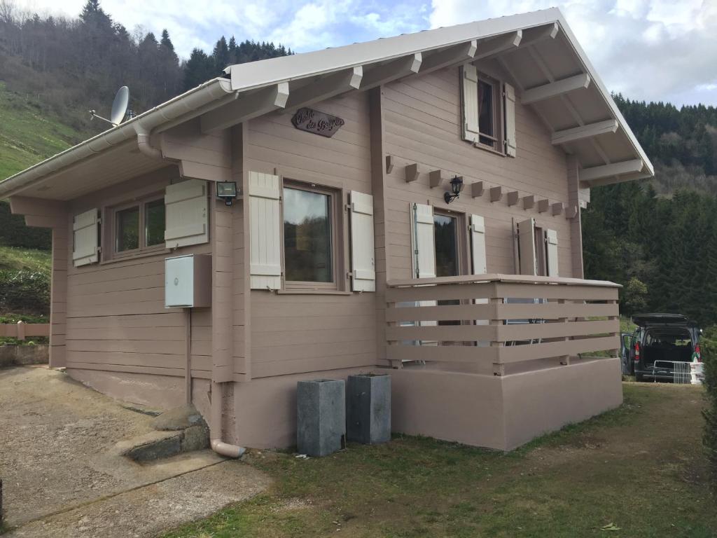 une petite maison avec une terrasse couverte sur le côté. dans l'établissement Les Bruyeres, à La Bresse