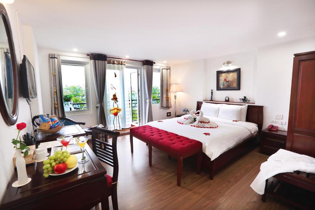 una camera con un grande letto e una panca rossa di Hanoi Siva Luxury Hotel & Travel a Hanoi