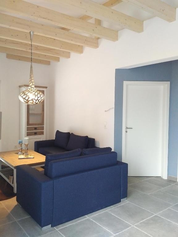 a living room with a blue couch and a table at Ferienhaus Pfaffensee in Harthausen