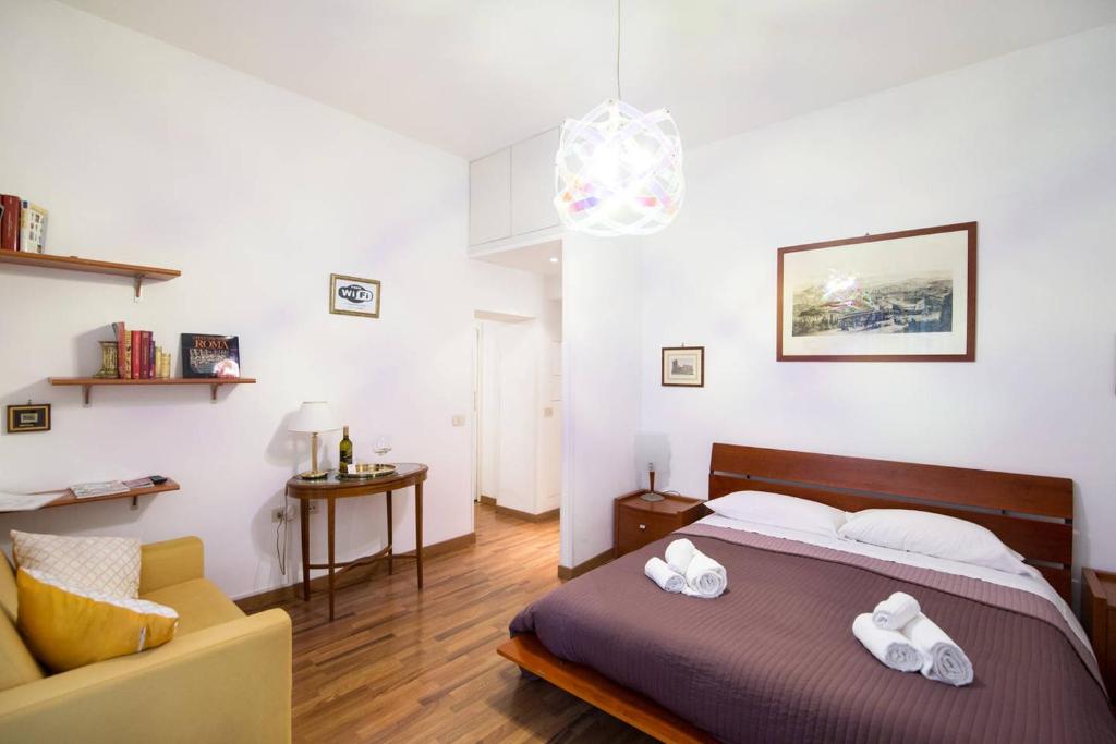 ein Schlafzimmer mit einem Bett und einem Sofa in der Unterkunft Parvula Domus al Colosseo in Rom