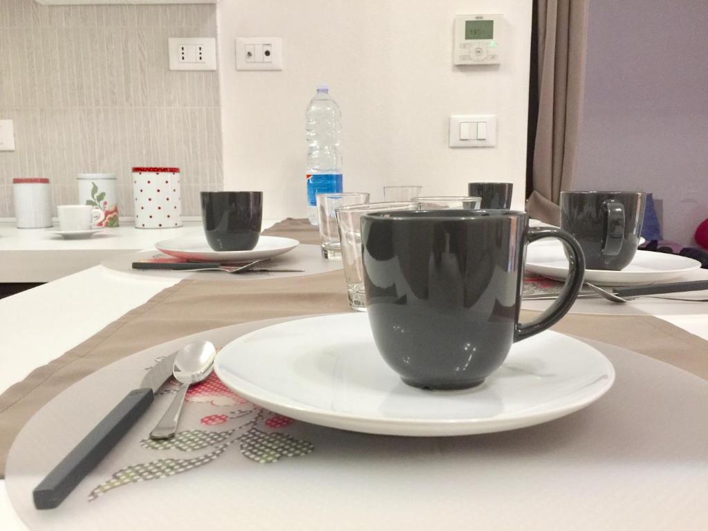 eine Kaffeetasse auf einem Teller auf einem Tisch in der Unterkunft Residenza Sant Orsola Azzurra Mazzini self check in in Bologna