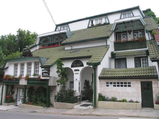 une grande maison blanche avec un toit vert dans l'établissement Pensiunea Ana Maria, à Târgu-Mureş