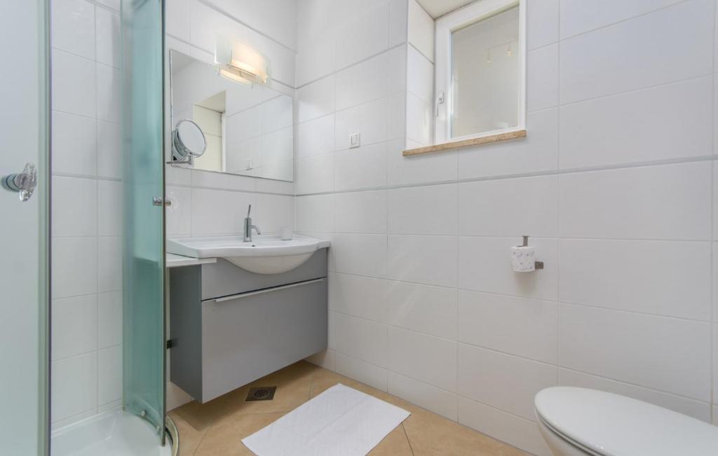 biała łazienka z umywalką i toaletą w obiekcie Apartment Riva Porec w Poreču