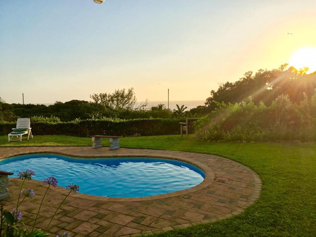 a swimming pool in a yard with the sun setting at Sea Forever in Pennington