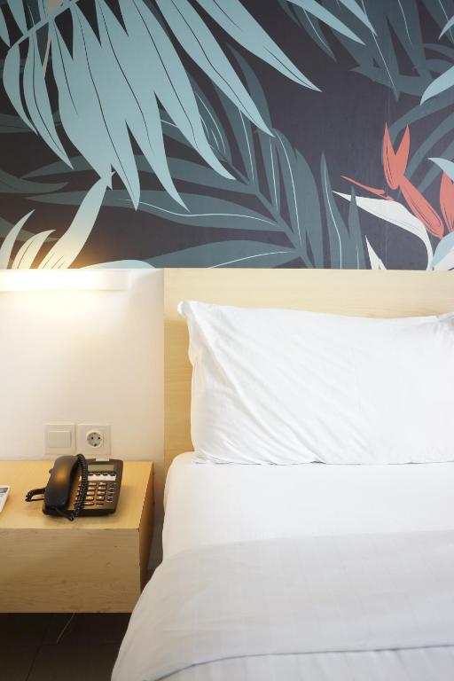 Postel nebo postele na pokoji v ubytování Liberta Hotel Kemang