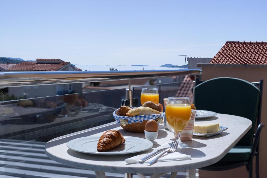 una mesa con comida y bebida en el balcón en Apartments Valentino, en Vodice
