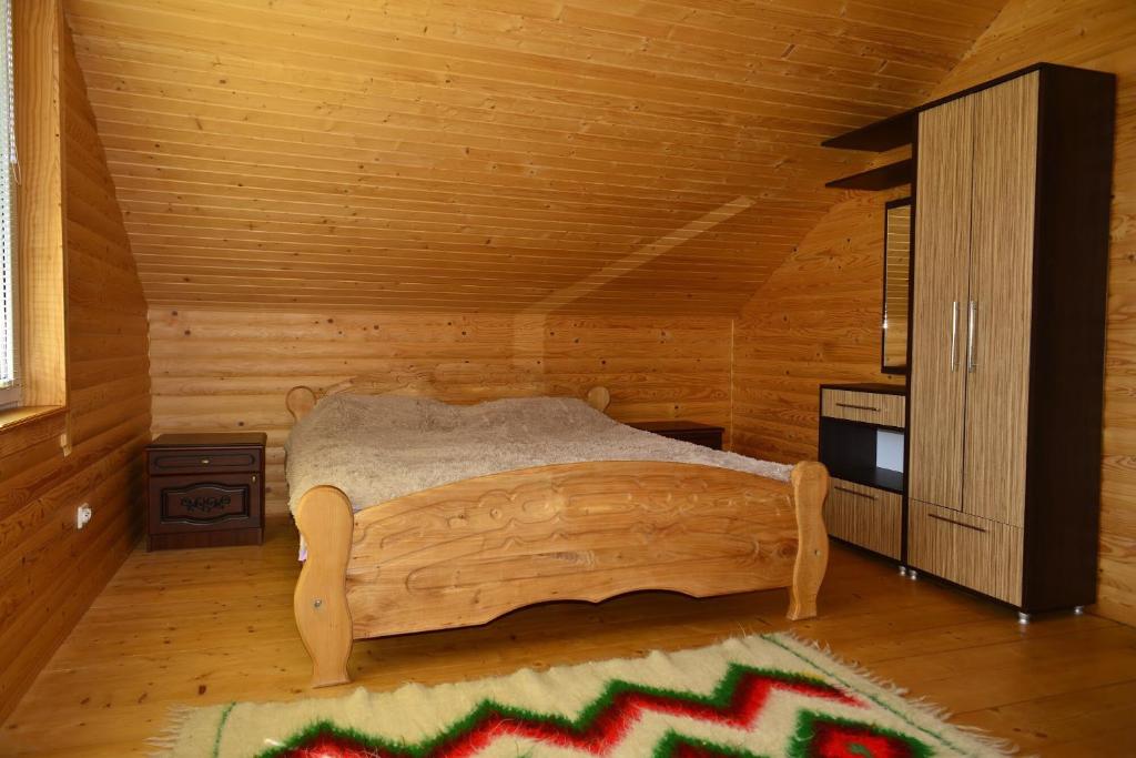 - une chambre avec un lit dans une cabane en rondins dans l'établissement Хатина в Карпатах, à Verkhovyna