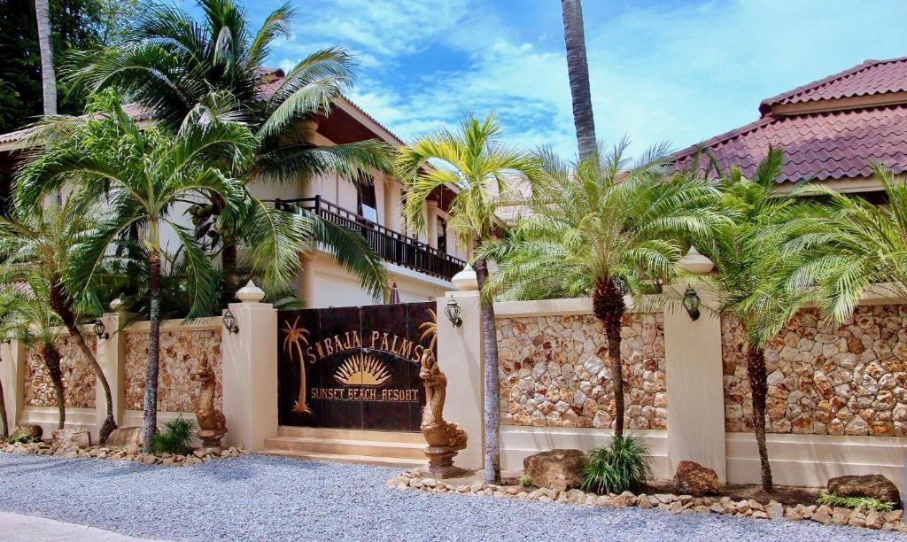 um edifício com palmeiras em frente em Sibaja Palms Sunset Beach Luxury Villa em Praia de Taling Ngam